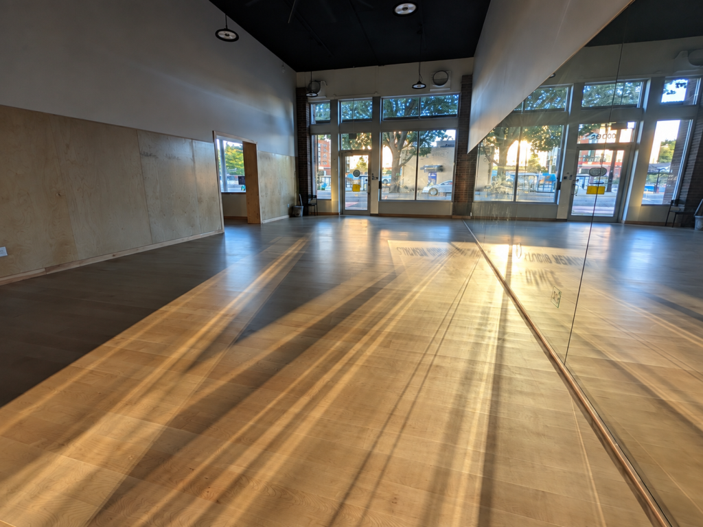 Sunlit 1,700-square-foot Seattle Capoeira Center with a professional sprung maple wood floor and mirrored training wall.
